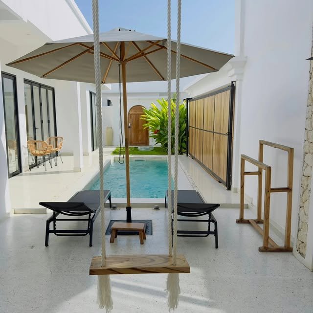 Private pool with a wooden swing seat and sun loungers